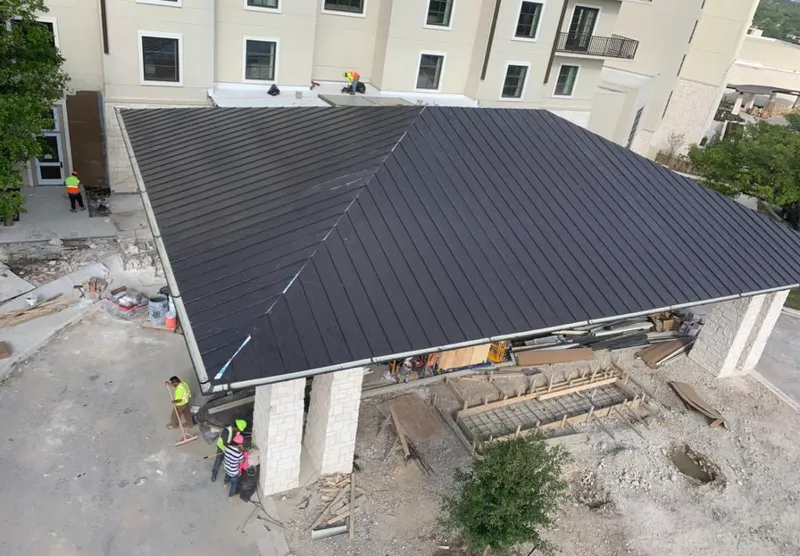Metal roofing installation team working on a commercial building in McCook